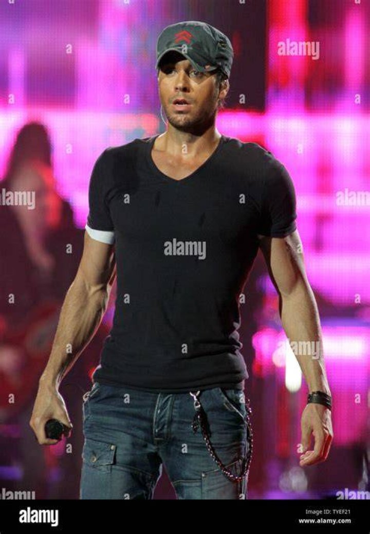 Enrique Iglesias performs in a navy blue shirt and a cap